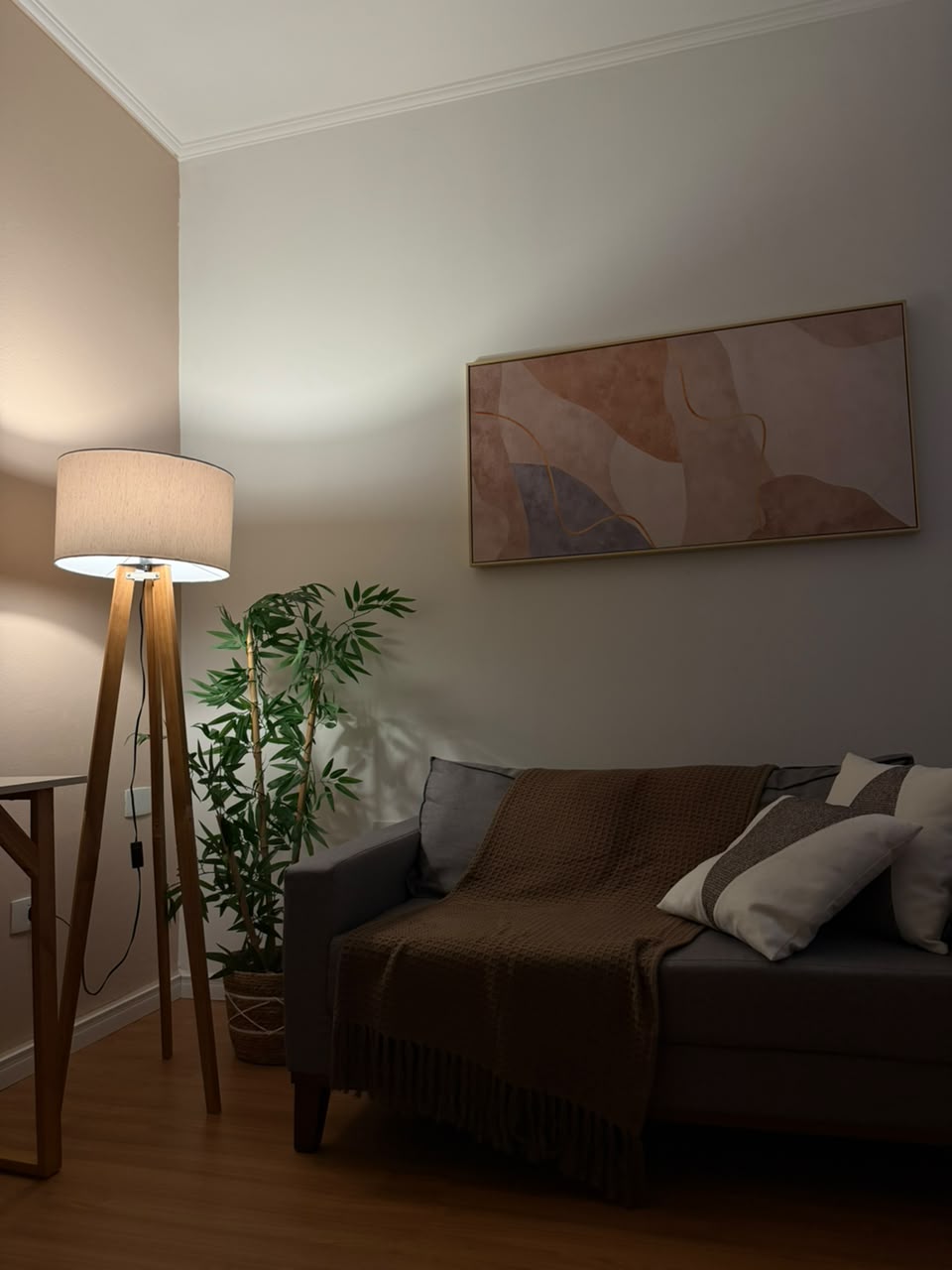 Sala de atendimento com sofá, luminária e quadro
